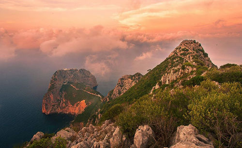 Panoramic view of rocks on sea against cloudy sky