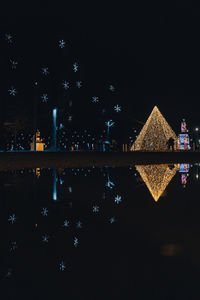 Reflection of illuminated building in lake at night