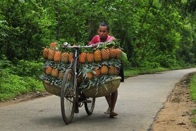 Rear view of man riding bicycle on road