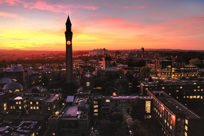 High angle view of city lit up at sunset