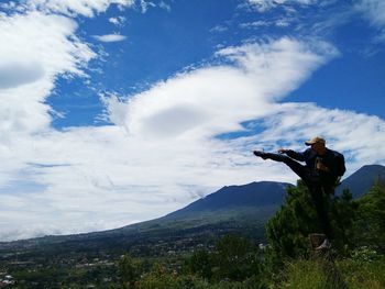 Low angle view of man on mountain against sky