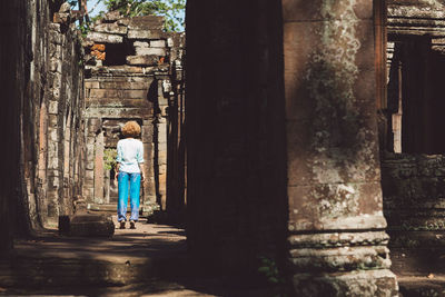 Rear view of mid adult woman standing at ankor wat temple