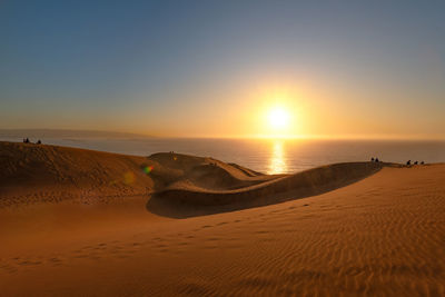 People watching the sunset from the dune field of concon, chile