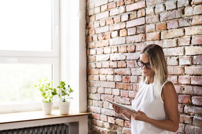 Woman in front of brick wall