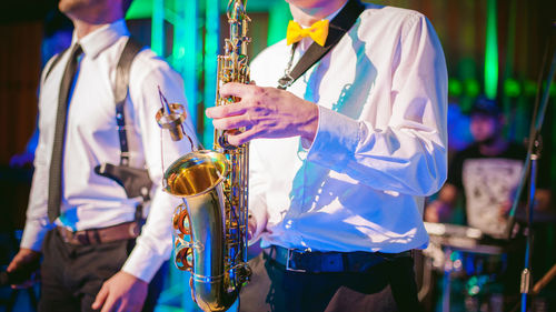 Midsection of men playing at music concert