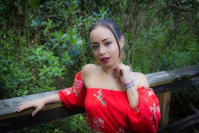 Portrait of smiling young woman standing in park