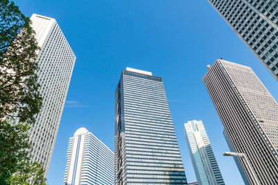 Low angle view of modern buildings against clear blue sky