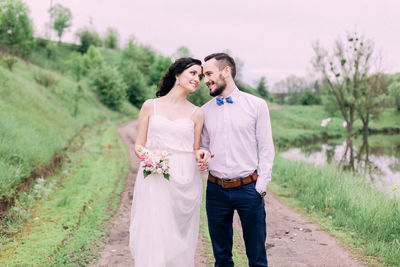 Young couple standing by plants