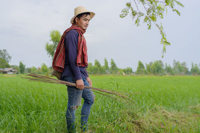 Full length of man standing on grass against sky