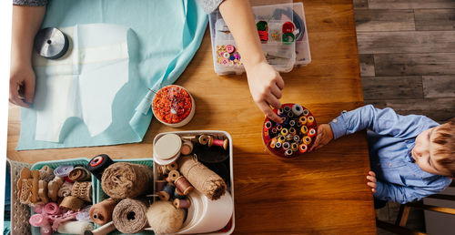 High angle view of people with spools on table