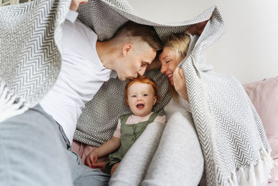 Full length of father with baby on bed