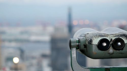 Close-up of coin-operated binoculars against sea