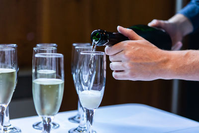 Midsection of man holding wine glass on table