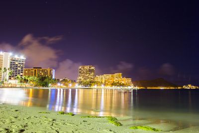 Illuminated cityscape against sky at night