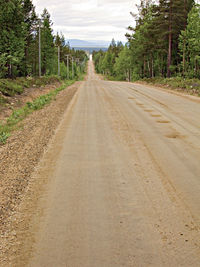 Road amidst field against sky