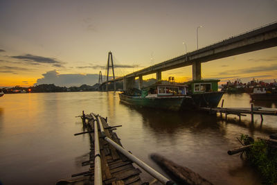 Bridge over river against sky during sunset