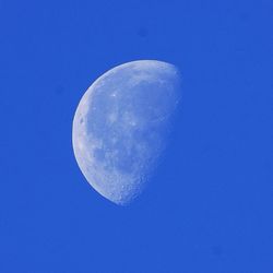 Low angle view of moon against blue sky