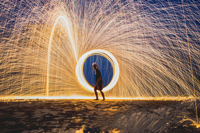 Full length of light trails against sky at night