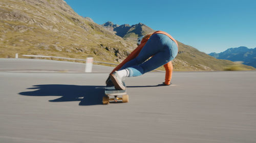 Rear view of woman walking on road