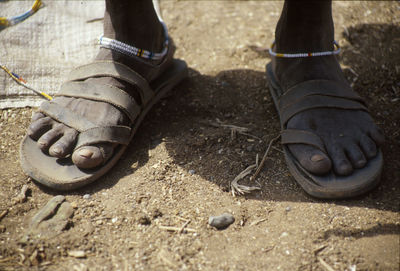 Low section of dirty legs in slipper at serengeti national park during sunny day