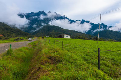 Scenic view of field against cloudy sky