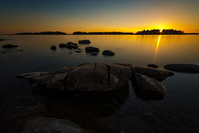 Rocks in lake at sunset