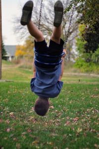 Playful boy on swing at park