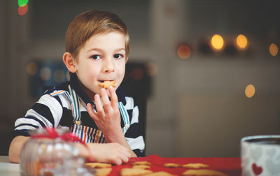 Portrait of boy holding ice cream on table