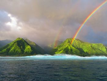 Scenic view of rainbow over sea against sky