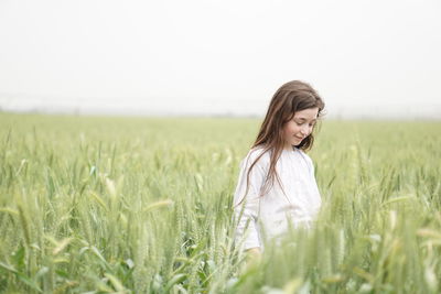 Young woman standing in wheat field