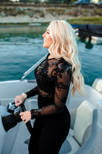 Beautiful young woman in black dress standing in vessel