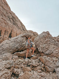 Young woman in summer clothes walking on rocky terrain on pag island in croatia.