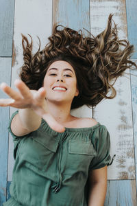 Portrait of smiling young woman lying on floor