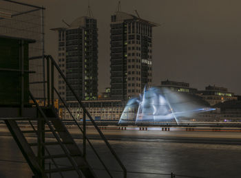 Illuminated city against sky at night