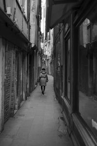 Rear view of man walking on street in city