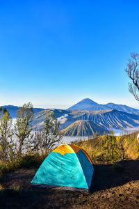 Tent against mountain range and blue sky