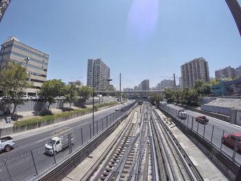 Railroad tracks amidst buildings in city against clear sky