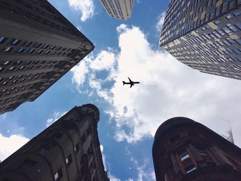 Low angle view of airplane flying against sky