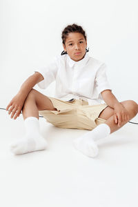 Portrait of doctor holding stethoscope against white background