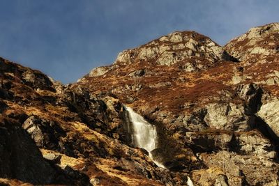 Scenic view of waterfall against sky