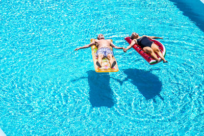 High angle view of people relaxing in swimming pool