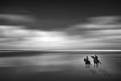 People walking on beach against sky