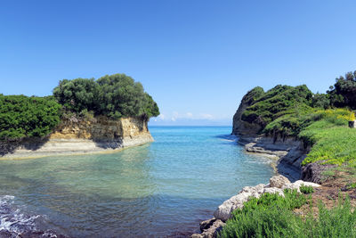 Scenic view of bay against clear blue sky