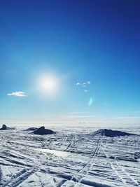 Scenic view of snow covered landscape against blue sky