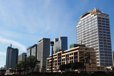 Low angle view of skyscrapers against blue sky