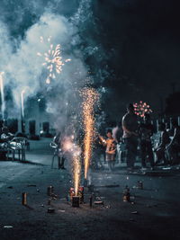 People watching firework display in city at night