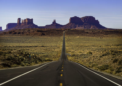 Road leading towards mountain against sky