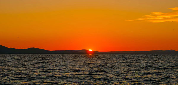 Scenic view of sea against romantic sky at sunset