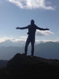 Full length of man standing on mountain against sky