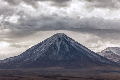 View of snowcapped mountain against cloudy sky